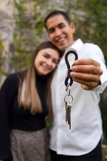Casal sorridente segurando as chaves da casa nova